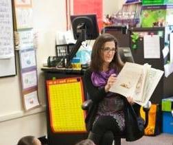 Faculty member reading to students in classroom